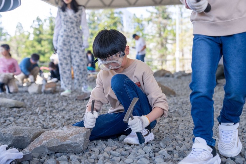 孩子戴護目鏡敲化石